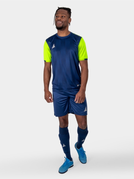 A model standing up wearing a Navy Football Training shirt, Navy Shorts and Navy Football Socks.