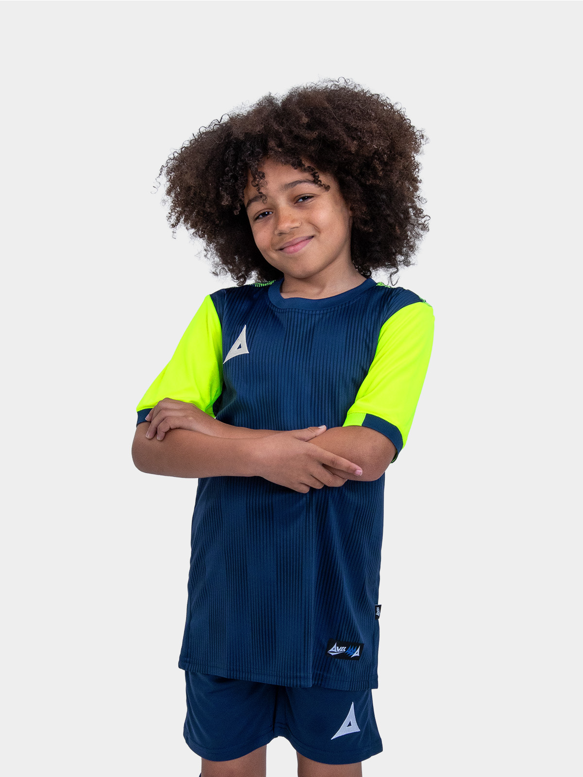 	a young child is wearing a navy football shirt with neon yellow sleeves. the football shirt has a two-tone graphic