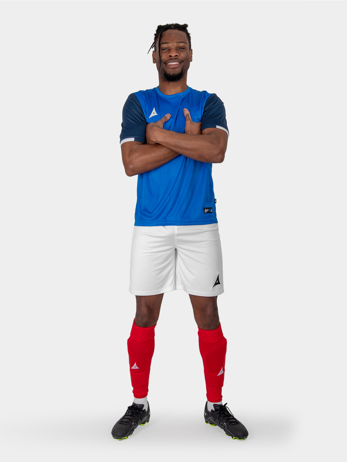 a man is wearing a royal blue and navy football shirt, combined with white shorts and red socks, akin to the france kit.