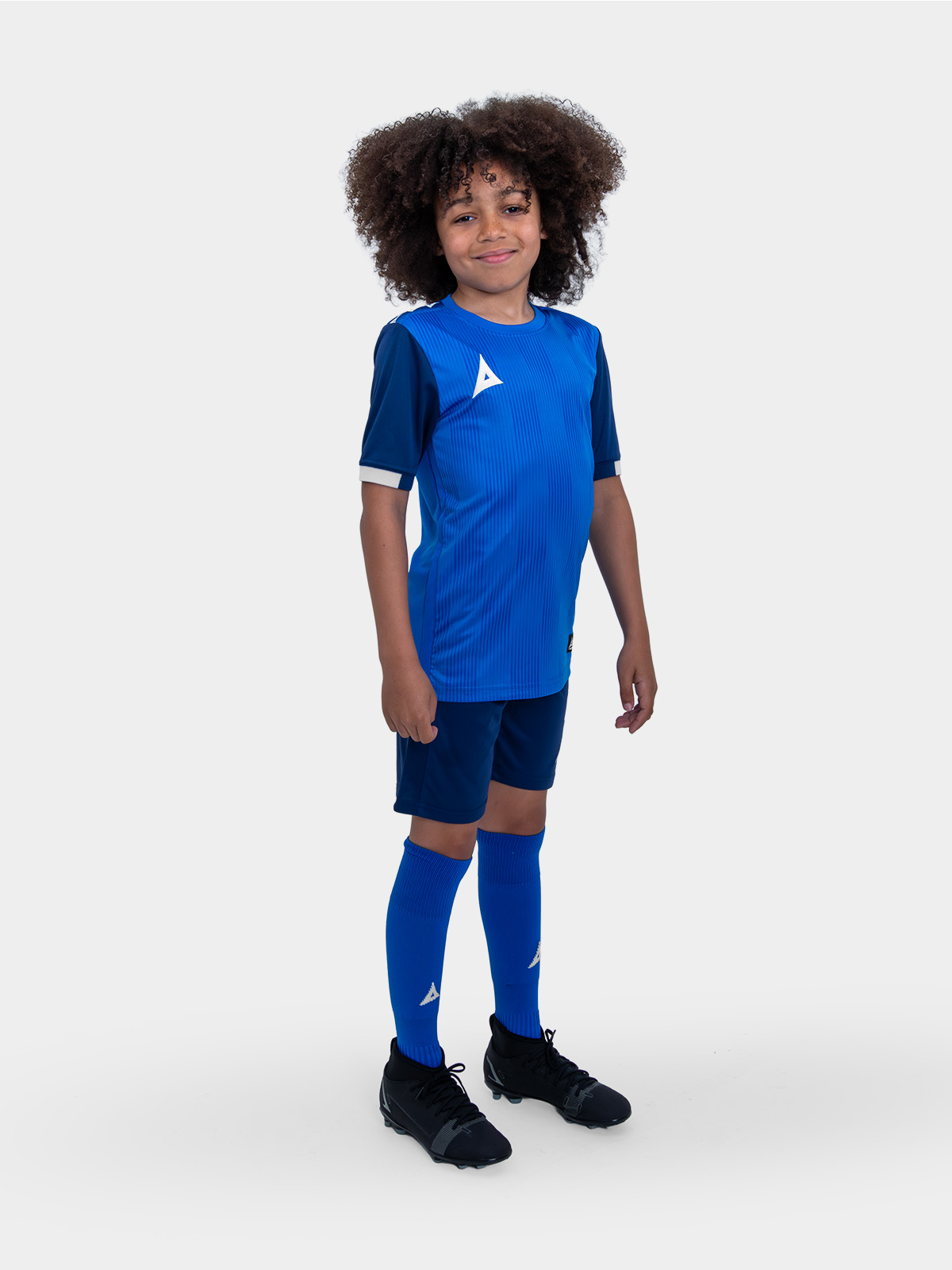 a young child is wearing a royal blue football kit, navy shorts and royal blue socks.