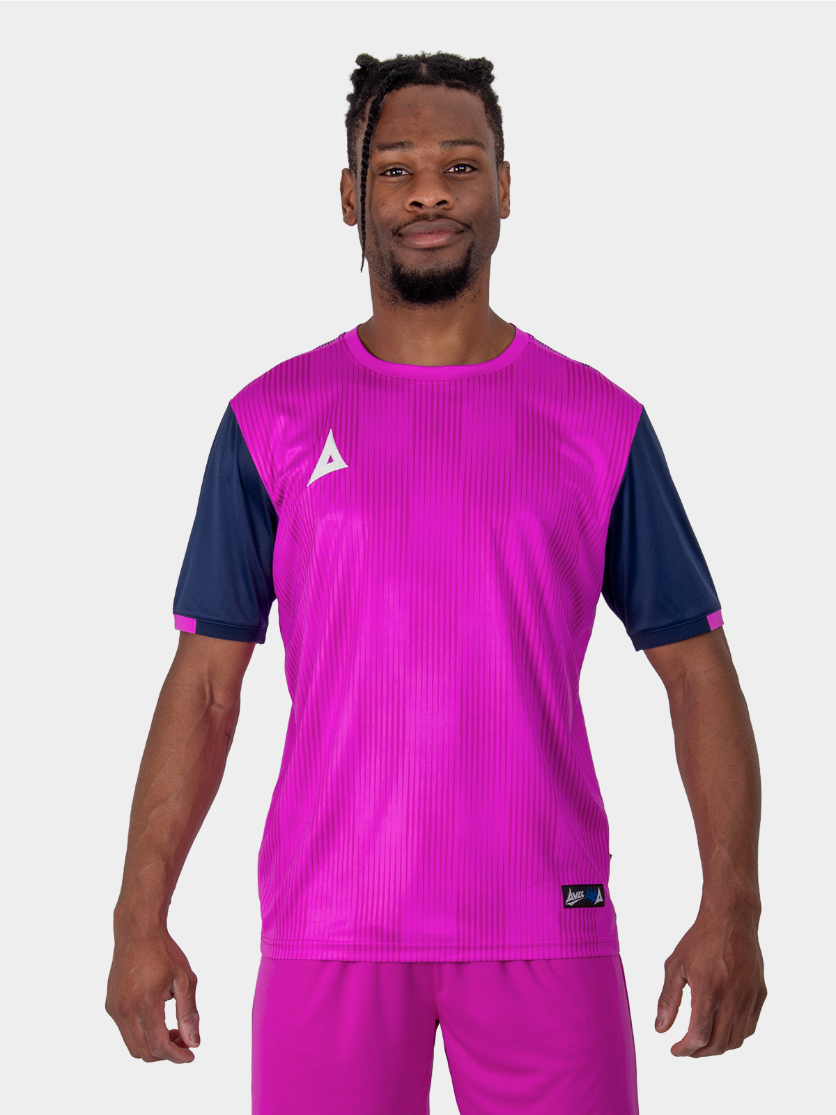a bright pink football shirt, with navy sleeves is worn by a man.
