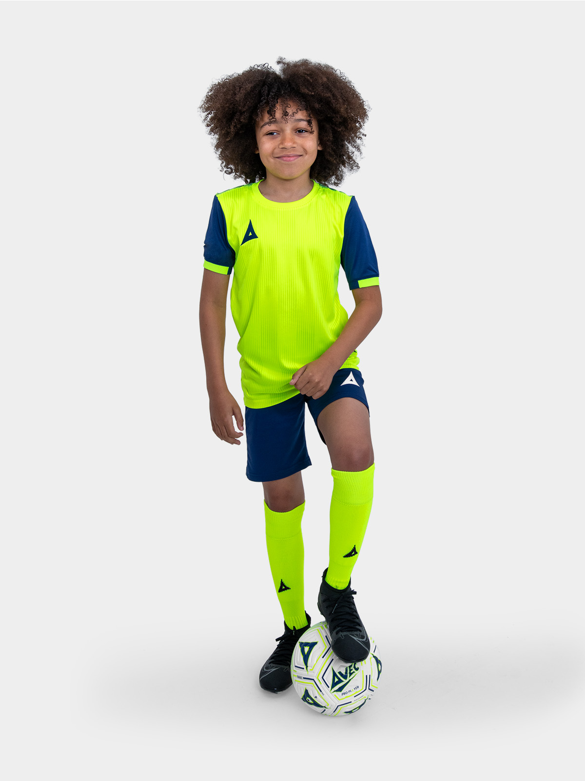 stand out in the new neon yellow football kit from avec sport. the junior is modelling a neon yellow shirt with navy sleeves, and is combined with navy shorts and neon yellow socks.