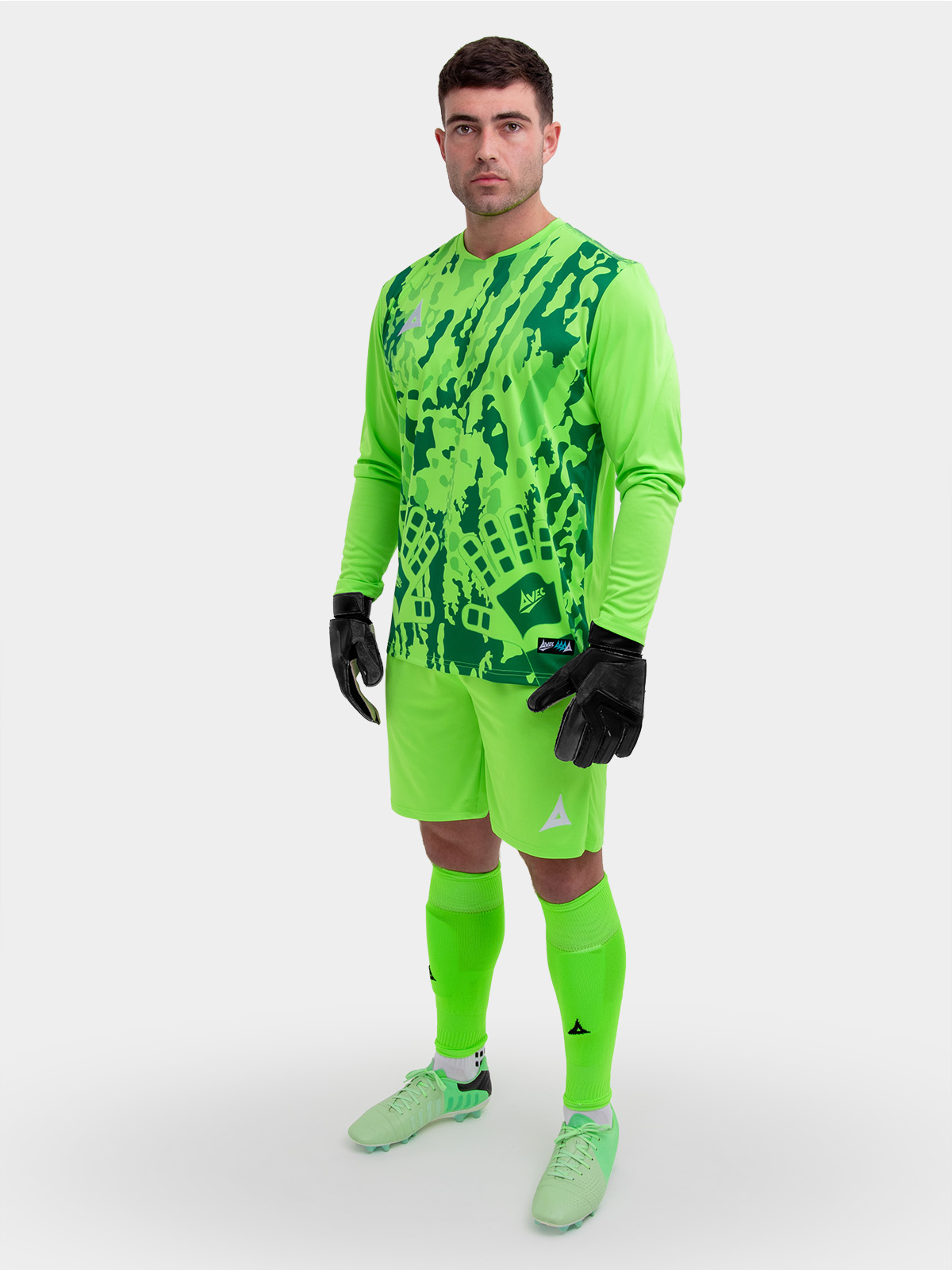 a model standing up wearing a neon green goalkeeper football shirt, neon green shorts and neon green football socks.