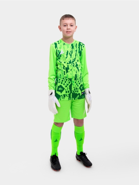 	A kid standing up wearing a neon green goalkeeper football shirt, neon green Shorts and neon green Football Socks.