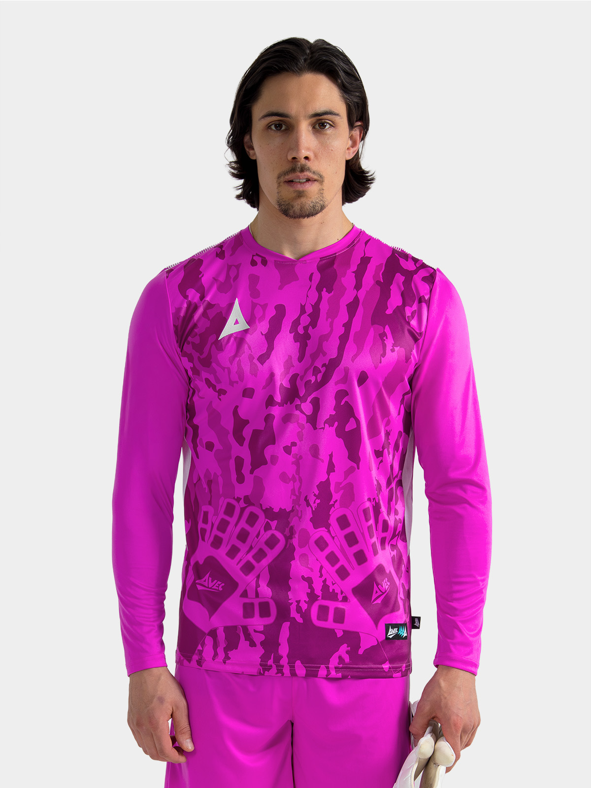 	a model standing up wearing a magenta goalkeeper football shirt with a camo pattern