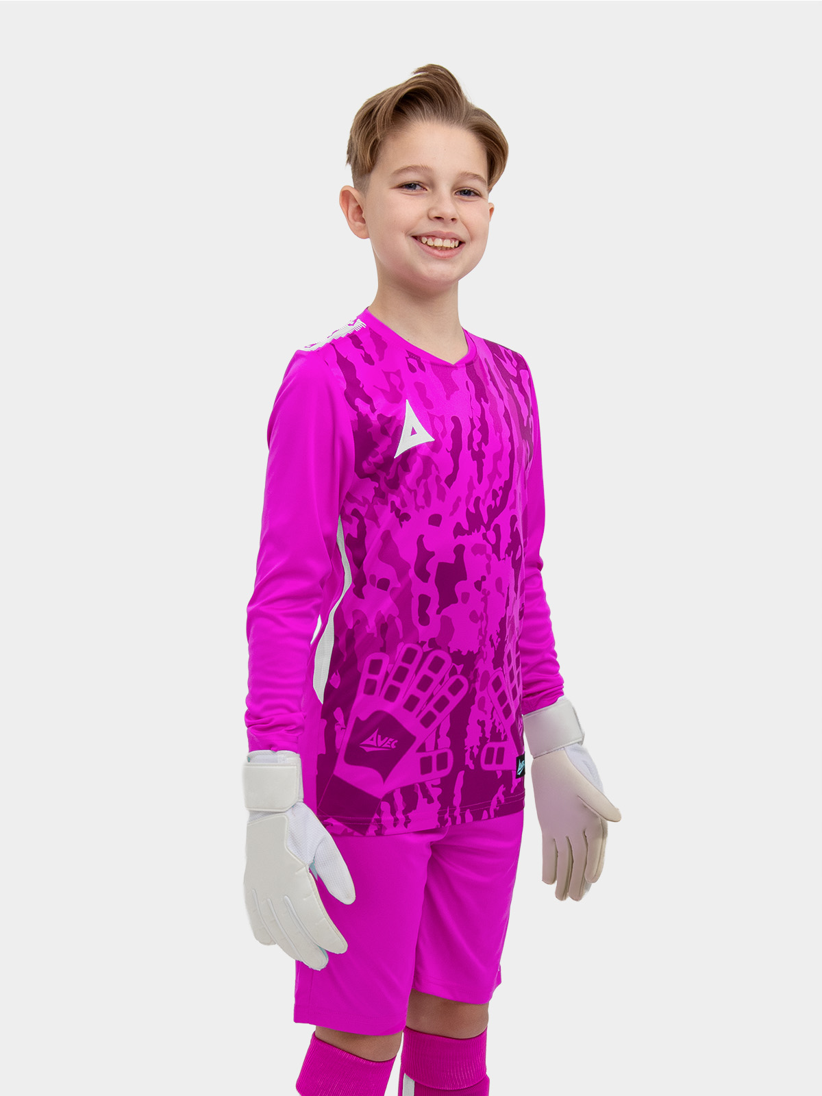 	a child standing up wearing a magenta goalkeeper football shirt