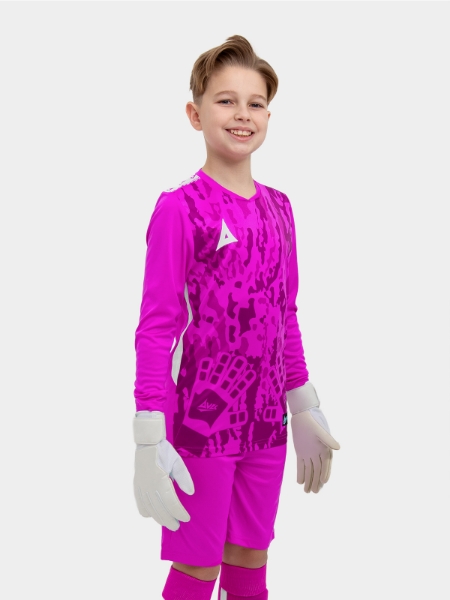 	A child standing up wearing a magenta goalkeeper football shirt
