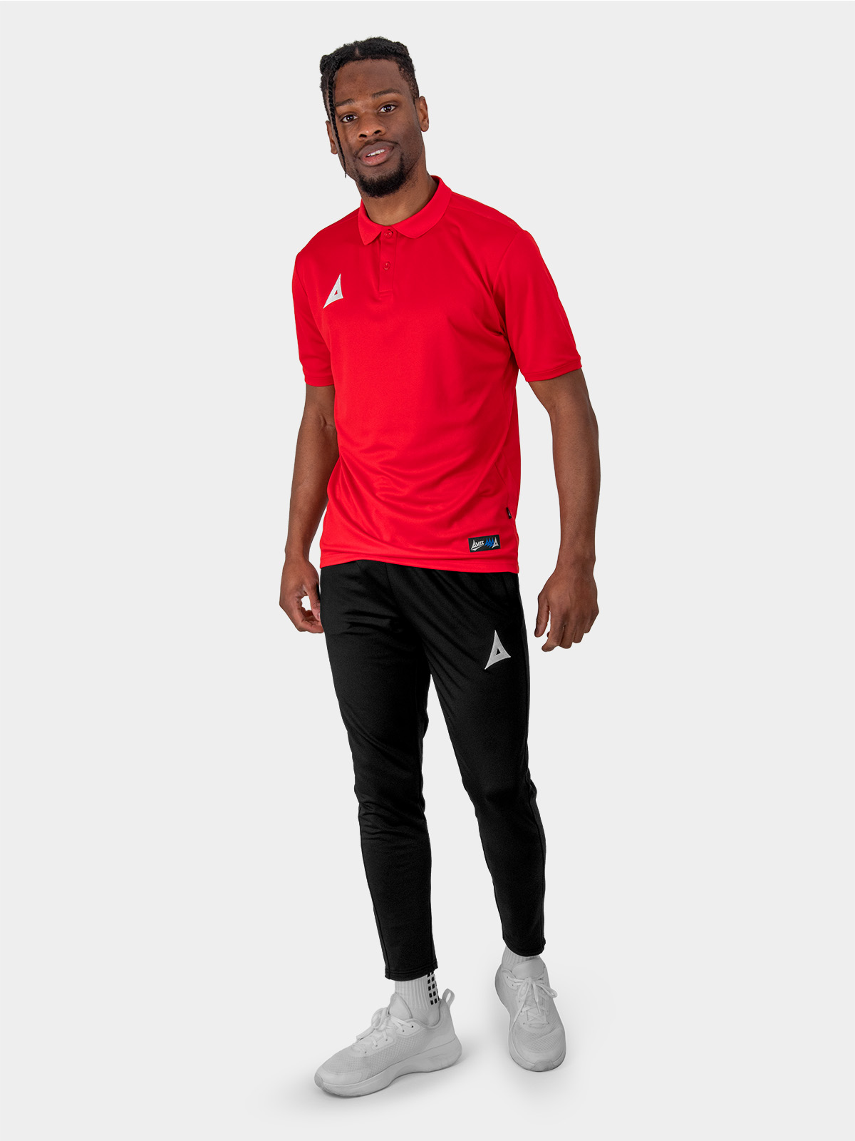 a male model is stood wearing the avec focus 2 red tech polo and the avec focus 2 black track pant joggers