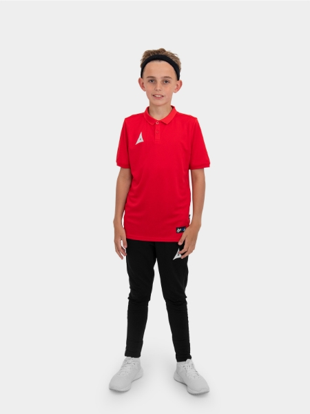 A boy is stood wearing the Avec Focus 2 Red Tech Polo and the Avec Focus 2 Black Track Pant, smart polo and joggers for training