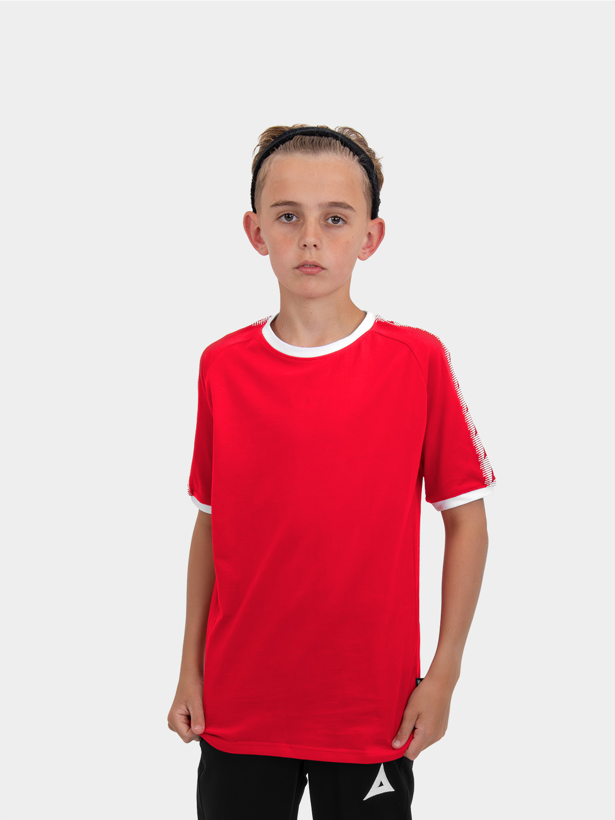 	a boy is stood wearing wearing the avec evolve red t-shirt, plain red top with sleeve detail