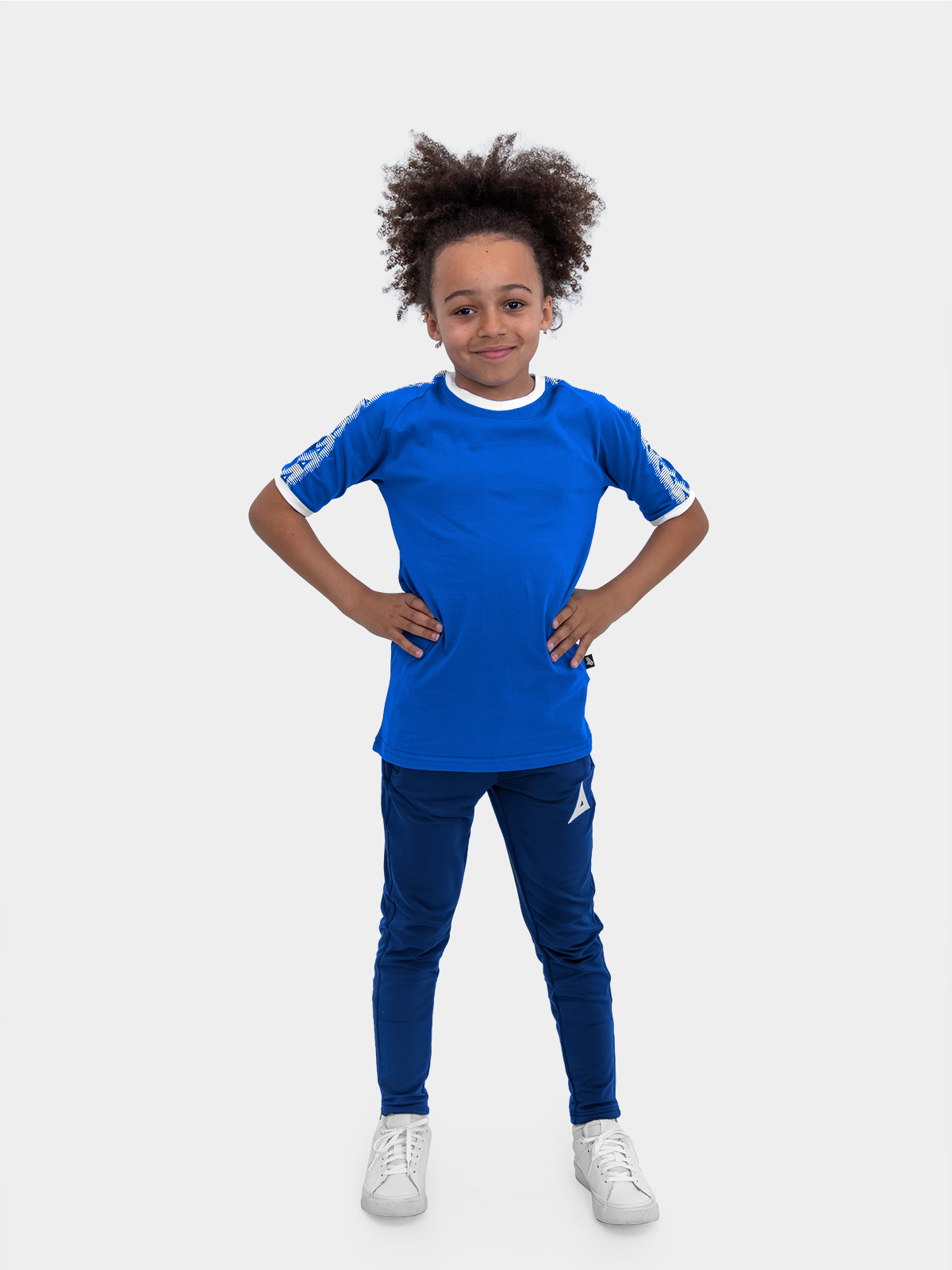 a boy is stood wearing wearing the avec evolve royal blue t-shirt and the avec focus 2 navy track pant
