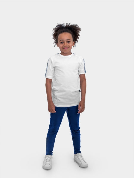 	A boy is stood wearing wearing the Avec Evolve White T-Shirt and the Avec Focus 2 Navy Blue Track Pant