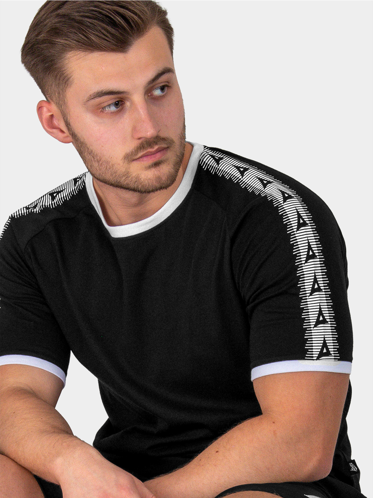 close-up of avec heritage 'a' logo taping on the avec evolve black t-shirt