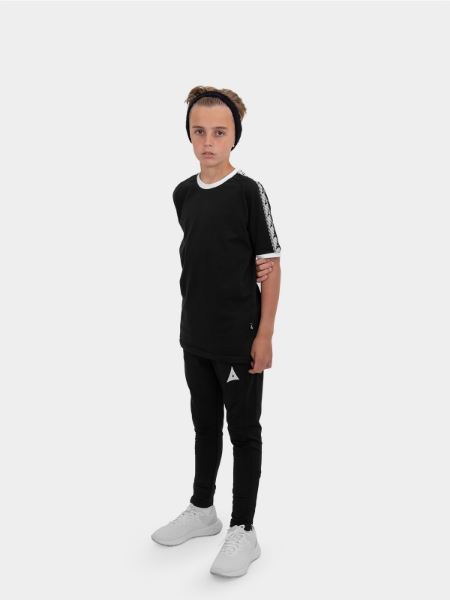 	A boy is stood wearing wearing the Avec Evolve Black T-Shirt and the Avec Focus 2 Black Track Pant