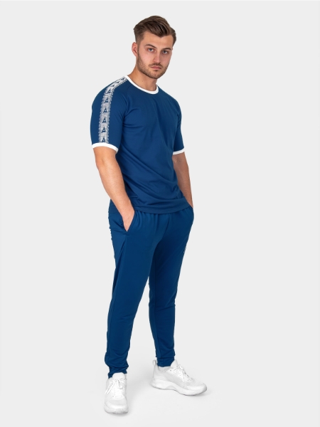 	A Male Model stood wearing the Avec Evolve Navy T-Shirt, with ribbed sleeve cuff and neck in white and matching Navy Avec Focus 2 Track Pants