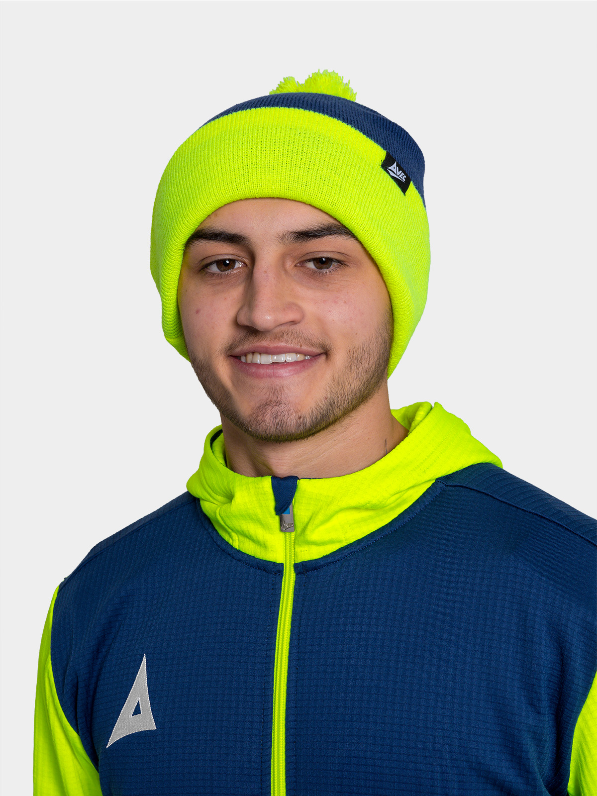 	person wearing dark blue and neon yellow beanie and athletic jacket