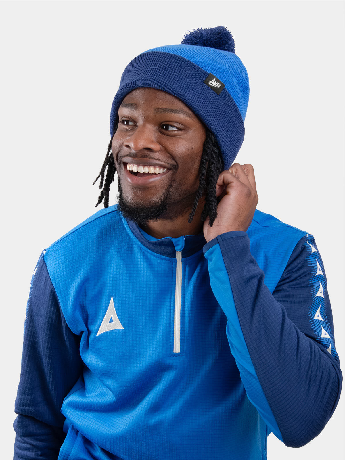 a man wearing a royal and navy blue bobble hat matching his overlay