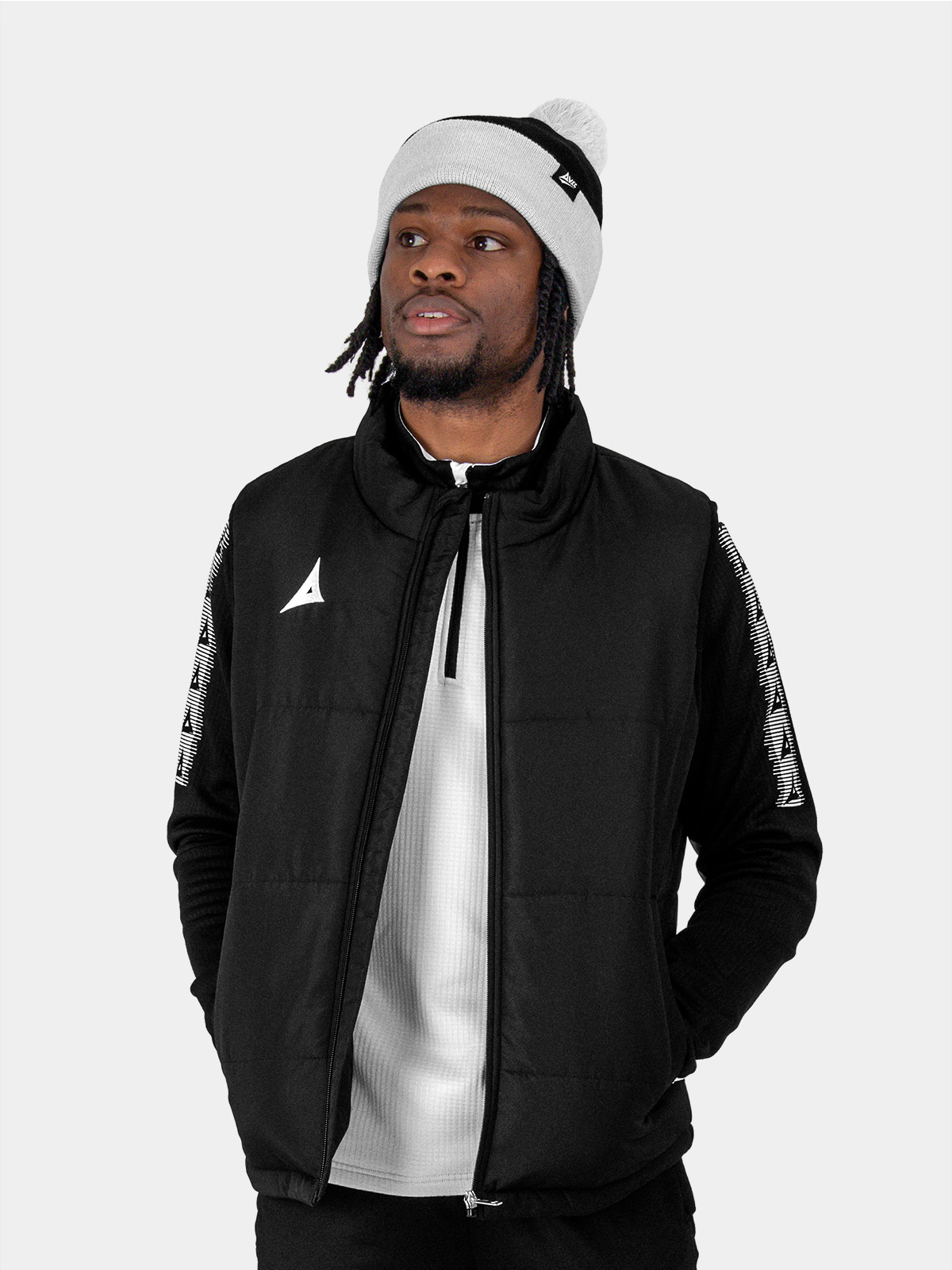 a man is wearing a grey bobble hat in black and grey.