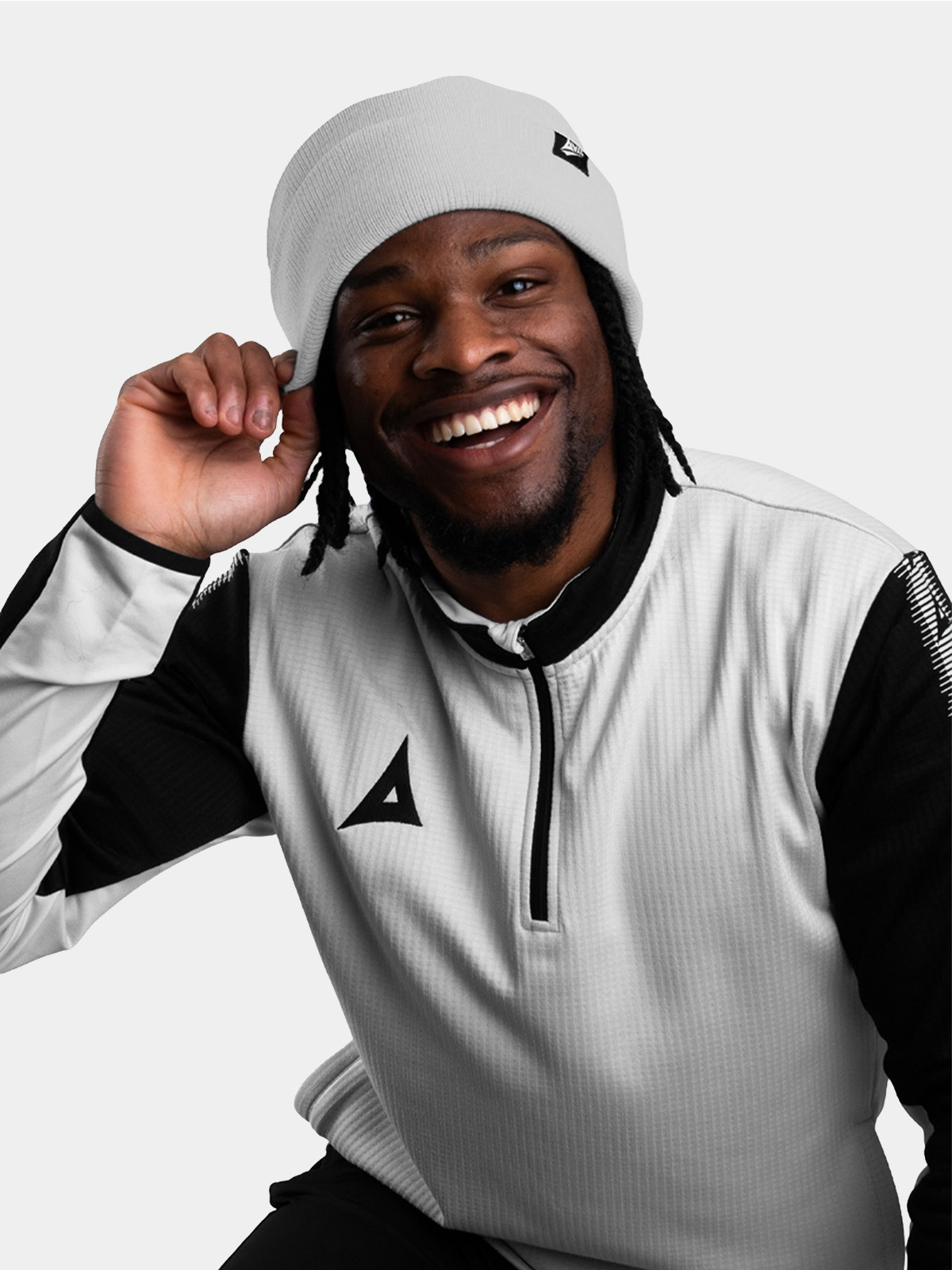 	a model wearing a matching grey beanie and overlay smiling