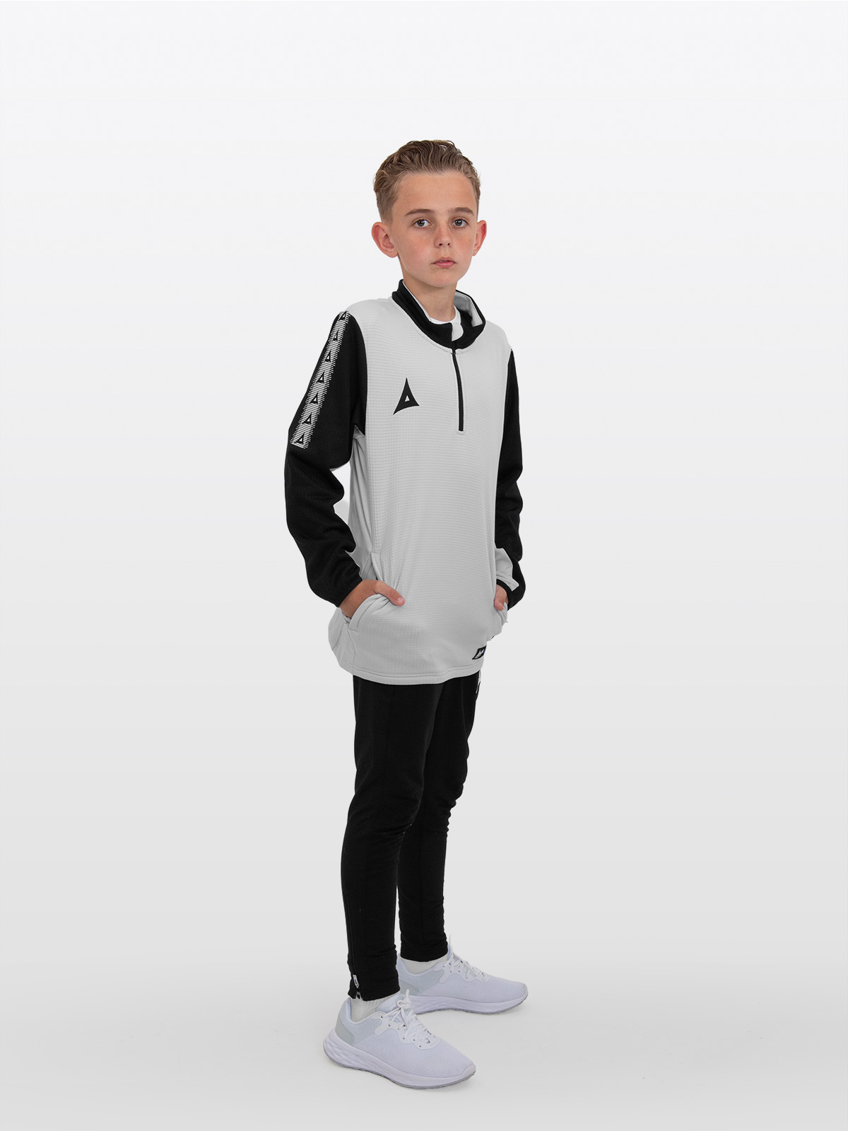 the child in this image is wearing a light grey sweat top in a junior size alongside black joggers.