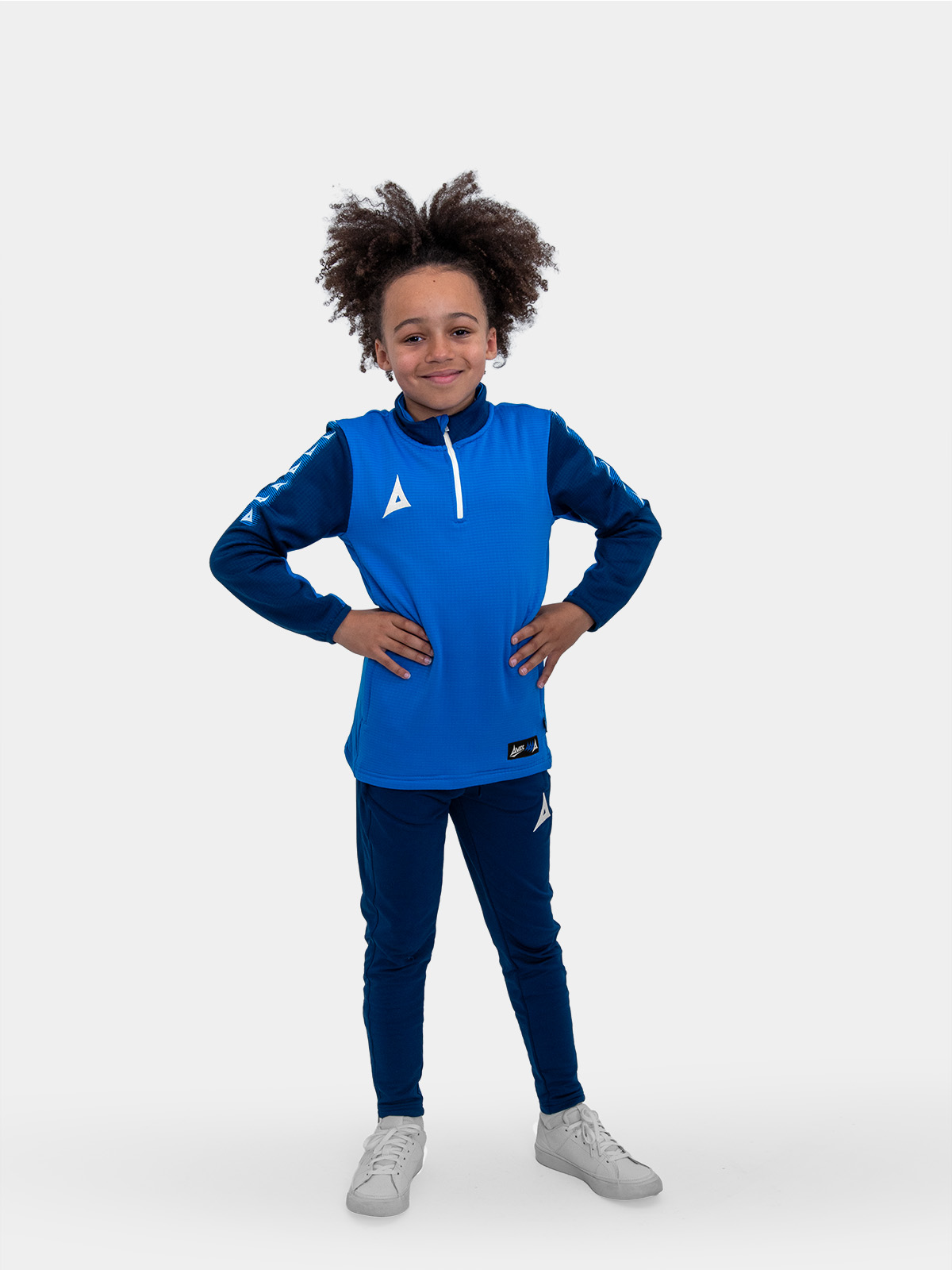 	with his hands on his hips, this young child is modelling a smart blue jumper