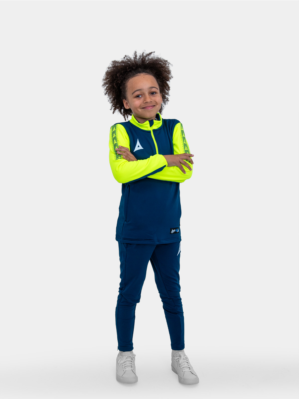 a kid with is hands on his hips wearing a navy blue sweat top with neon yellow sleeves.