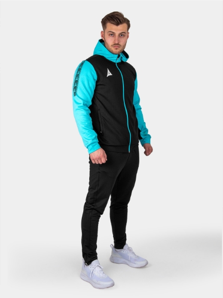 A man is wearing a a black hoody and joggers