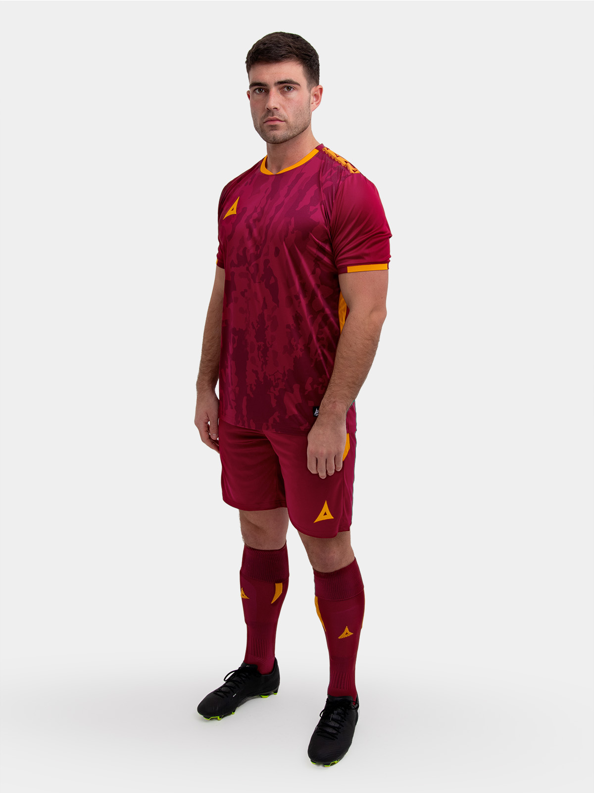 	a model standing up wearing a claret and amber football shirt, shorts and football socks.