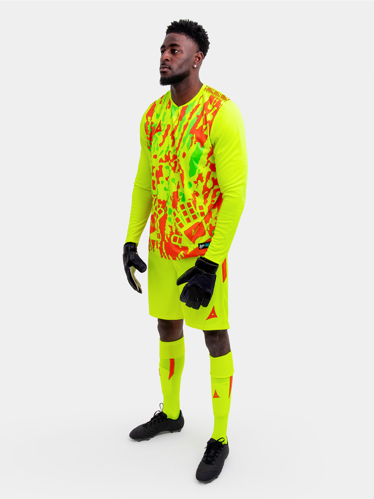 	a model is wearing a full neon yellow goalkeeper football kit and holding a neon yellow football matching the kit