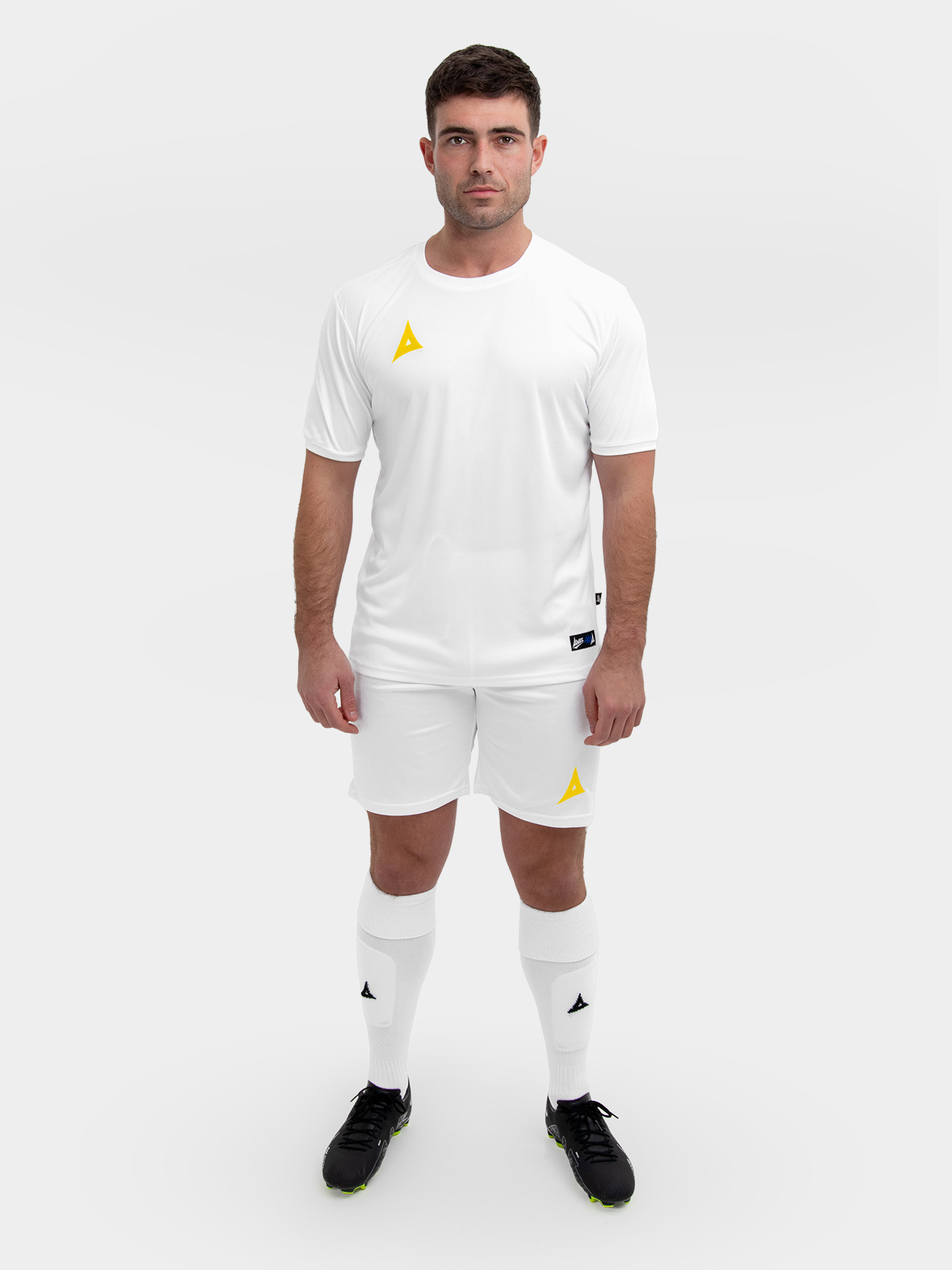 	a complete white football kit with yellow logos is being worn by this man.
