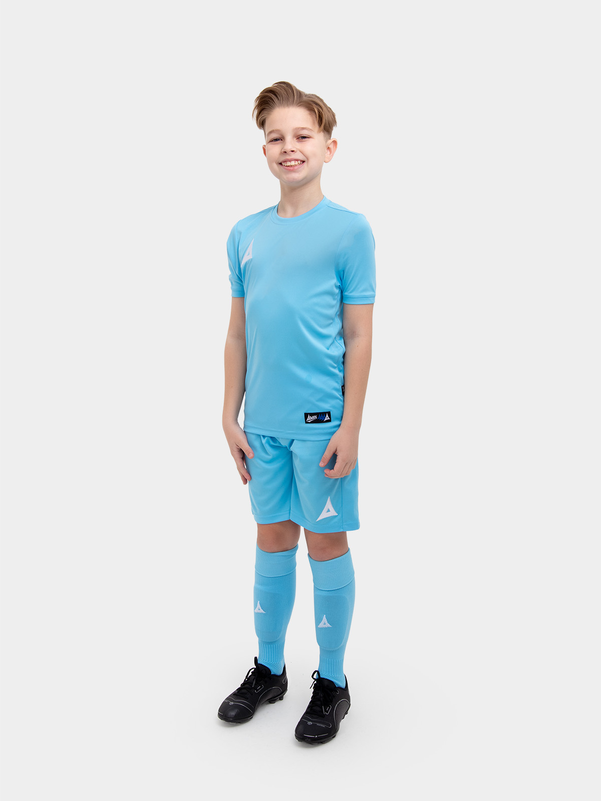 a young child is wearing a sky blue football shirt. he has matching shorts and socks