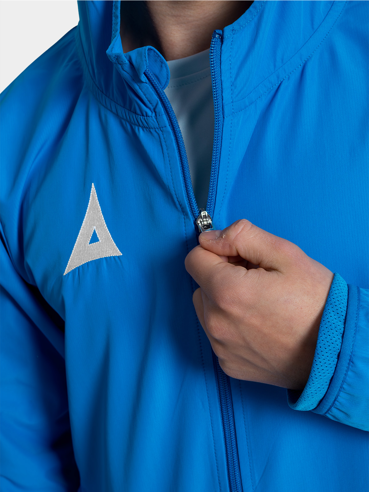 	close-up of the high-quality zipper on the royal blue football training jacket, built for frequent club use.