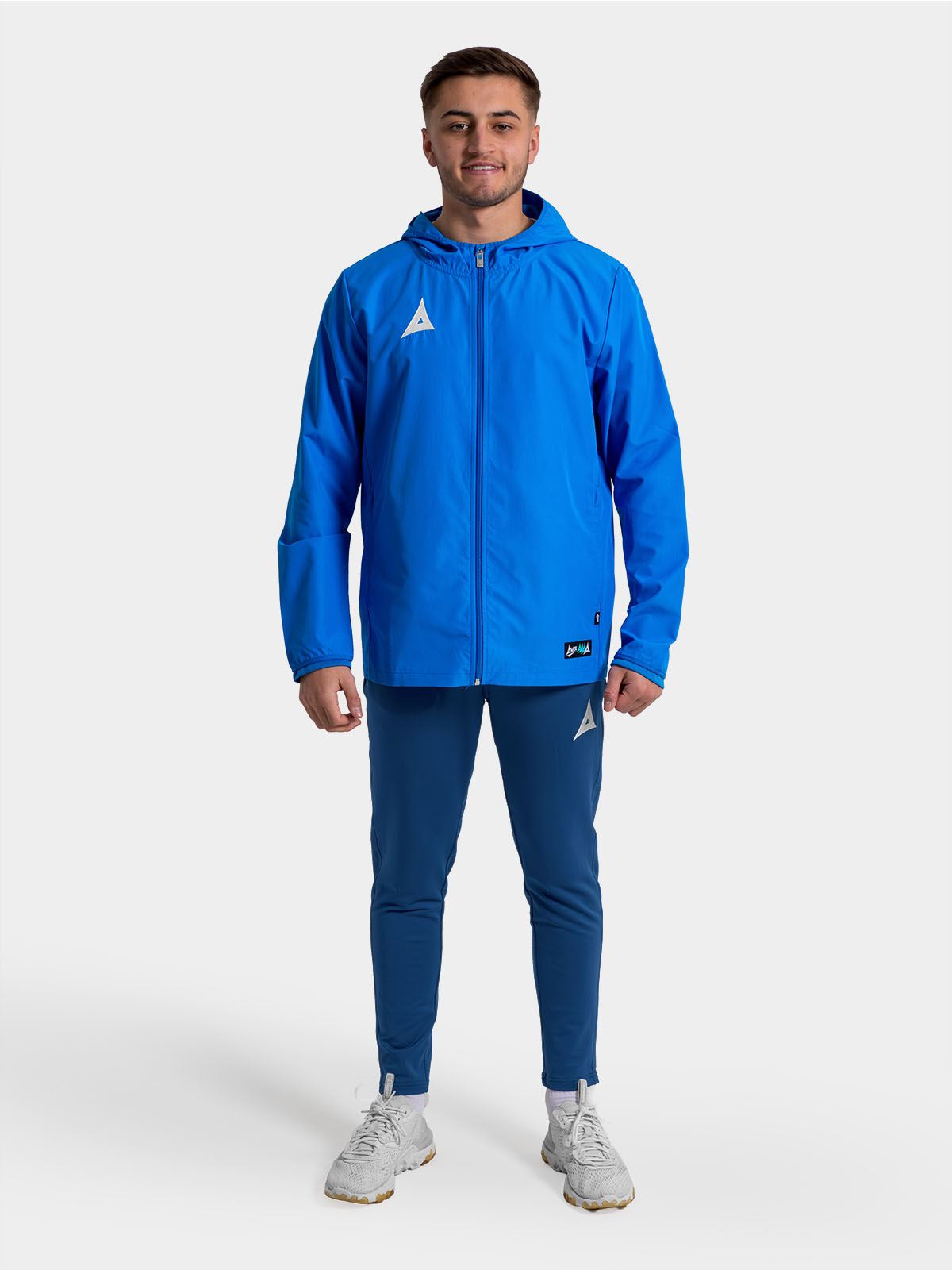 full-body view of a player in the royal blue focus 2 shell jacket, ideal for pre-match warm-ups.