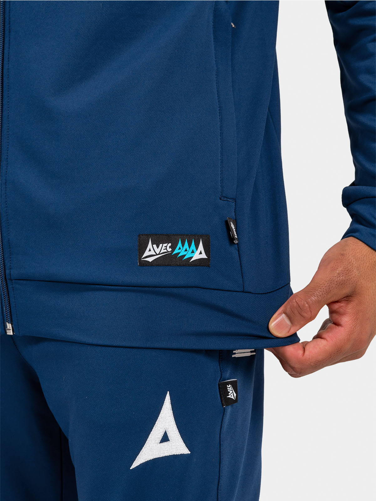 	detailed view of the navy hoody hem, showcasing the secure pocket for essentials and the authentic product tag.