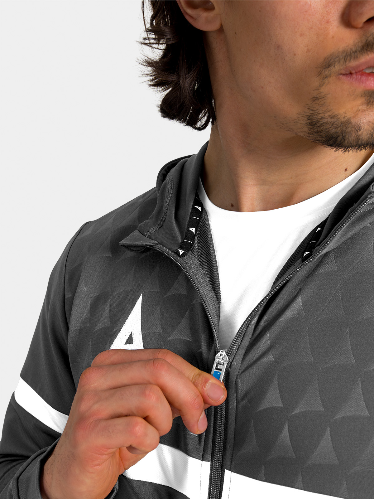 	front view of the anthracite hoody fully fastened, showcasing the clean lines and contrast debossed chest panel.