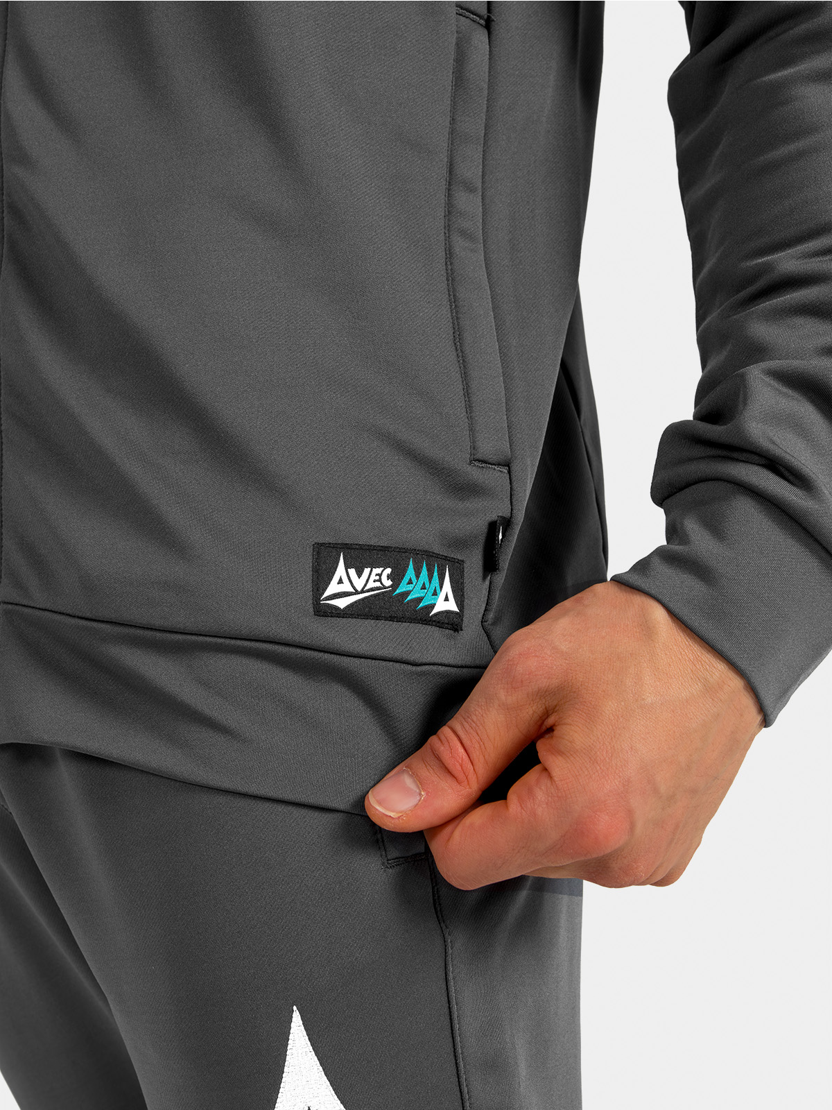 	macro shot of the anthracite hem, featuring the integrated side pocket and official avec sport authenticity label.
