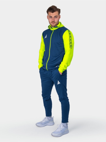 	A man sitting on a cube wearing a bright navy and yellow full zip hoody