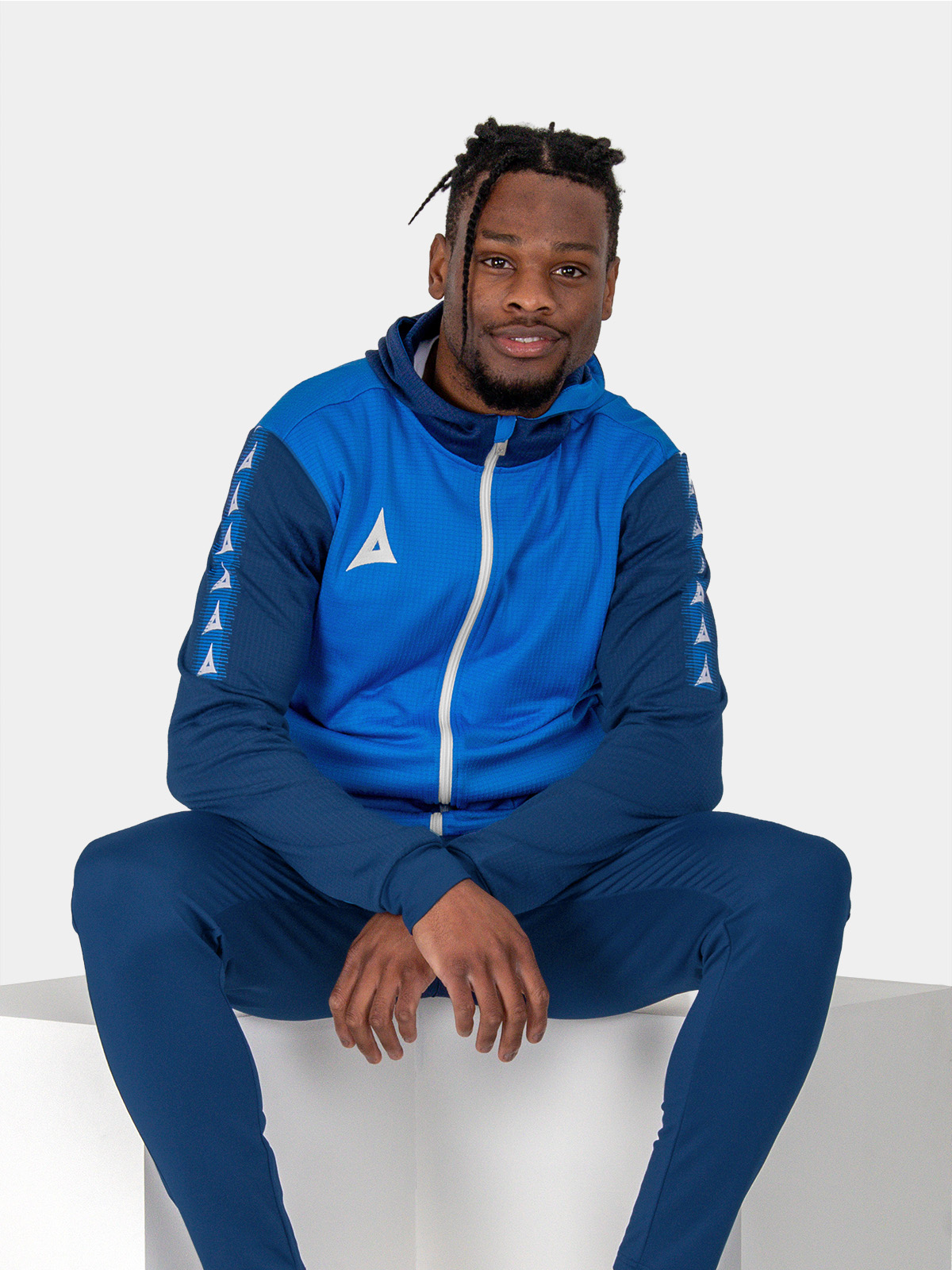 	a man looking relaxed in a blue hoody featuring a white zip