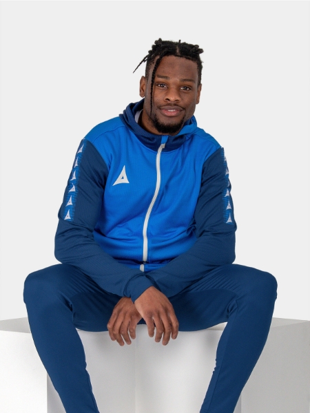 	A man looking relaxed in a blue hoody featuring a white zip