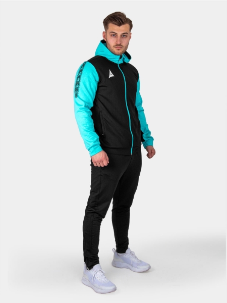 	A man is wearing a a black hoody and joggers