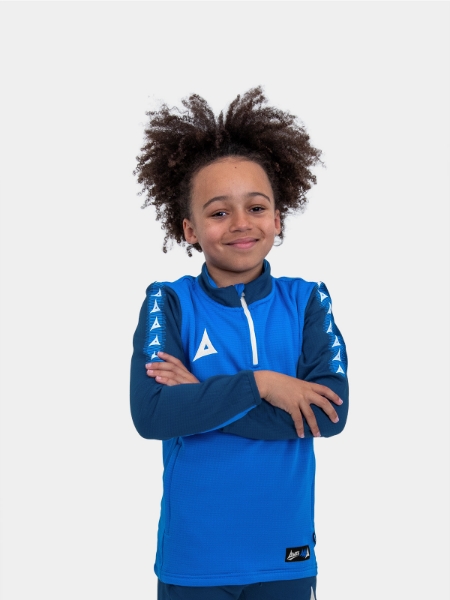 	With his arms folded, this young boy is wearing a soft and comfortable royal blue and navy jumper with a zip.