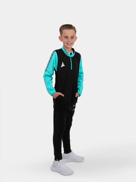 	A model is wearing a junior black jumper with zip and is complimented with black joggers