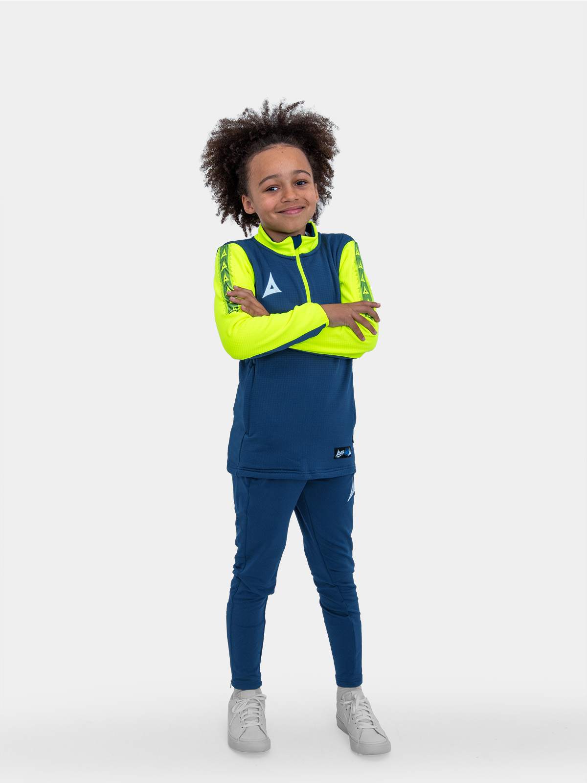 	a kid with is hands on his hips wearing a navy blue sweat top with neon yellow sleeves.