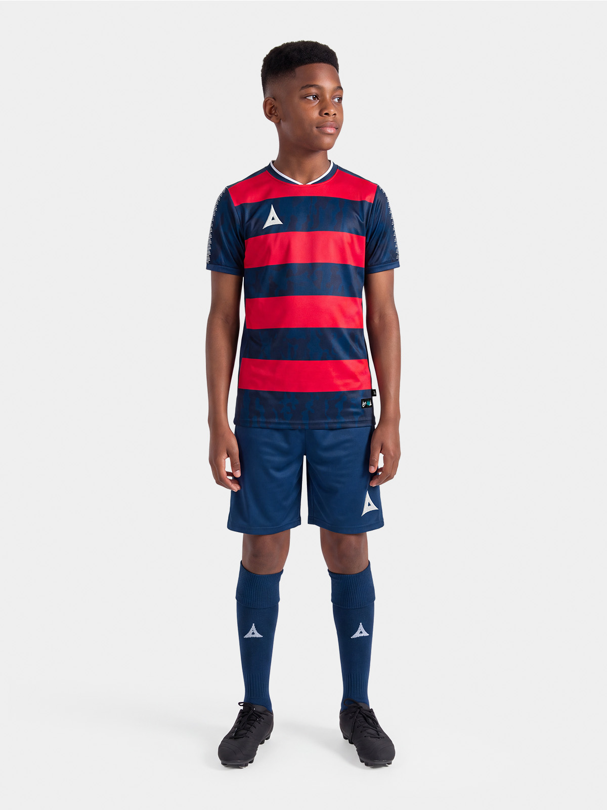 	complete navy and red football kit on-model, demonstrating the professional on-pitch appearance.