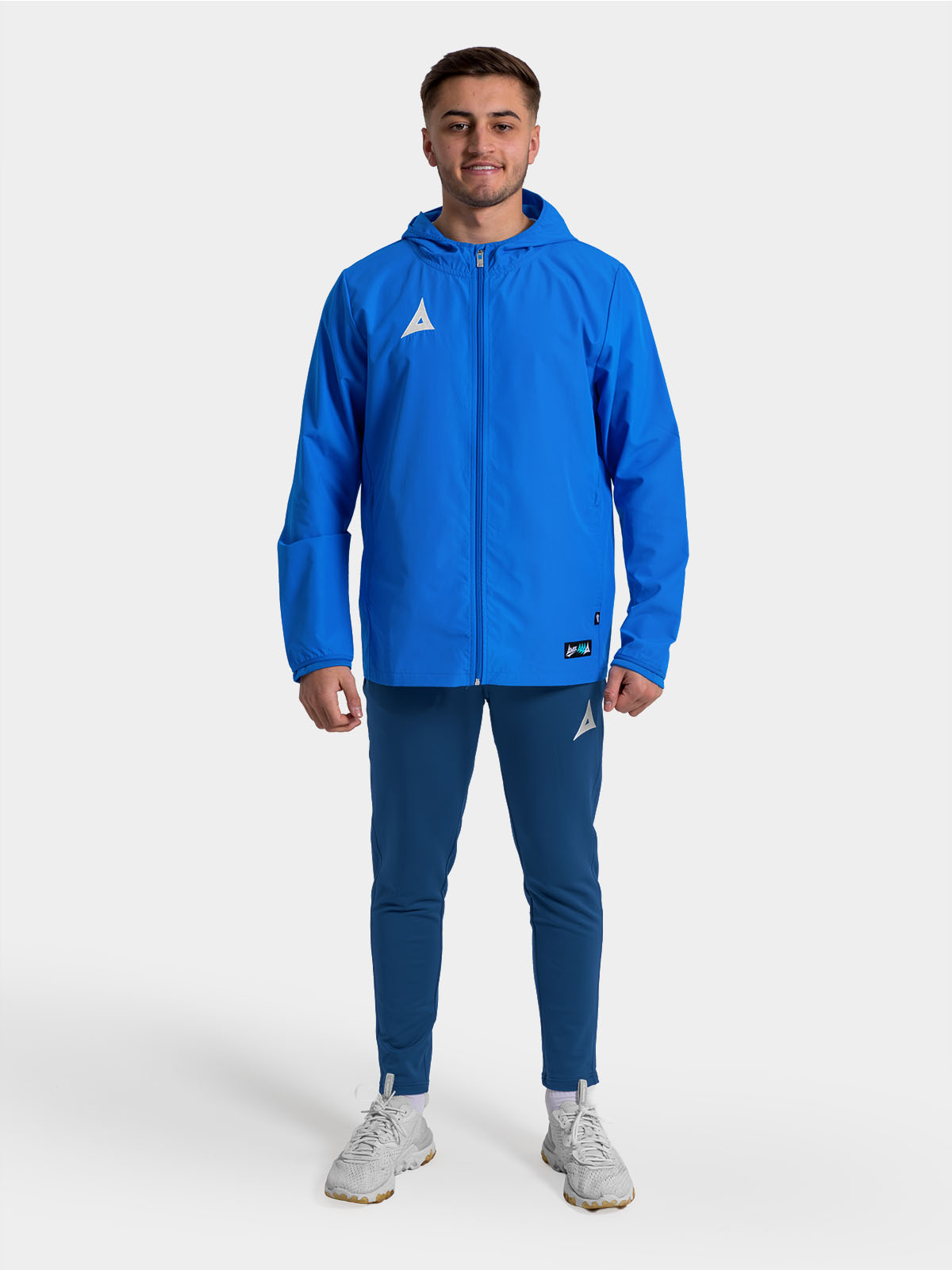 	full-body view of a player in the royal blue focus 2 shell jacket, ideal for pre-match warm-ups.