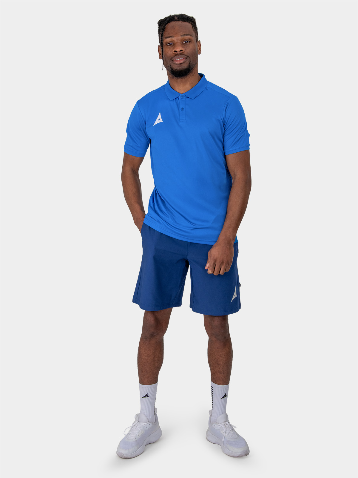 	a male model is stood wearing the avec focus 2 royal tech polo, plain royal blue top and the avec focus 2 navy track pant