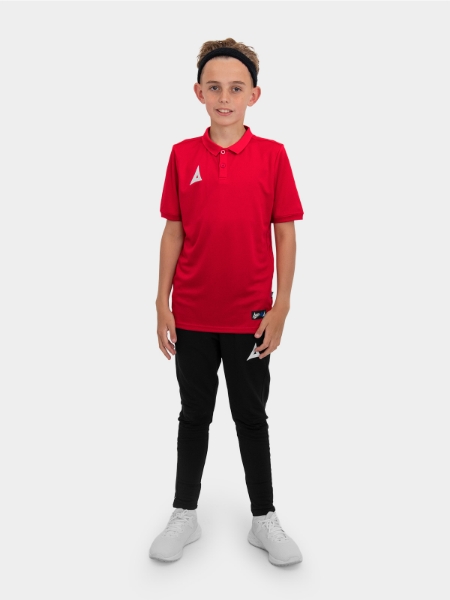 	A boy is stood wearing the Avec Focus 2 Red Tech Polo and the Avec Focus 2 Black Track Pant, smart polo and joggers for training