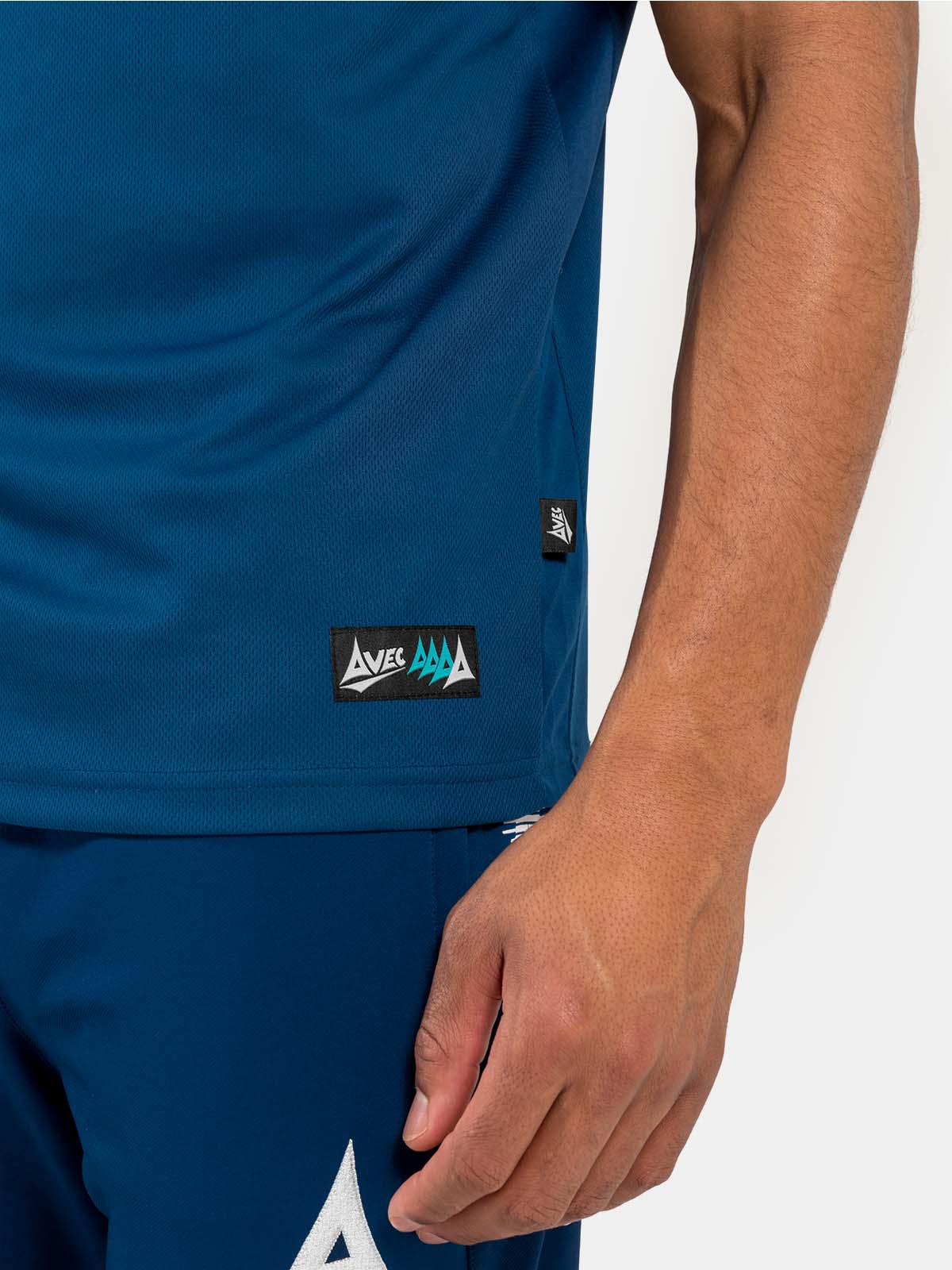 	side-hem detail of the navy polo, featuring the mesh ventilation and official authenticity tag.
