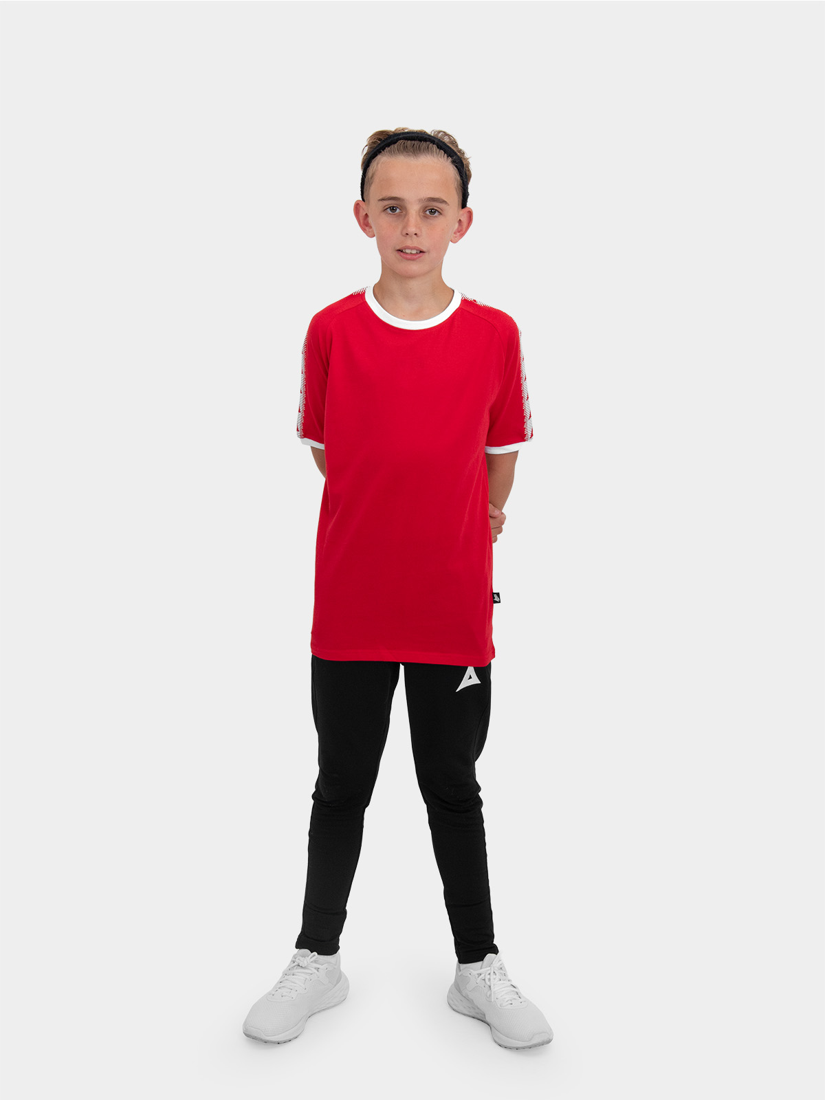 	a boy is stood wearing wearing the avec evolve red t-shirt and the avec focus 2 black track pant