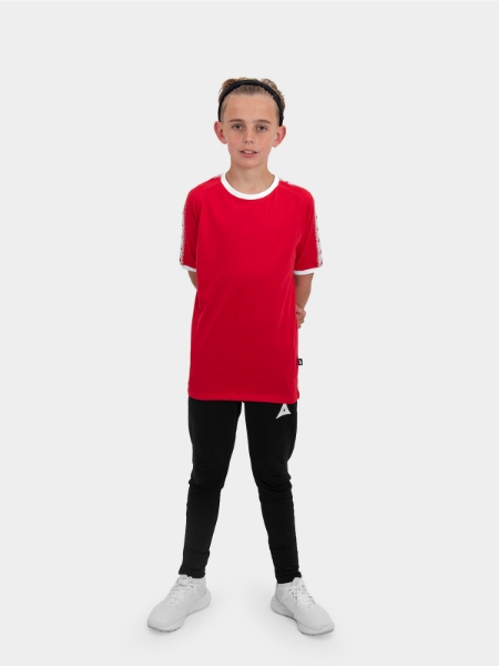 	A boy is stood wearing wearing the Avec Evolve Red T-Shirt and the Avec Focus 2 Black Track Pant